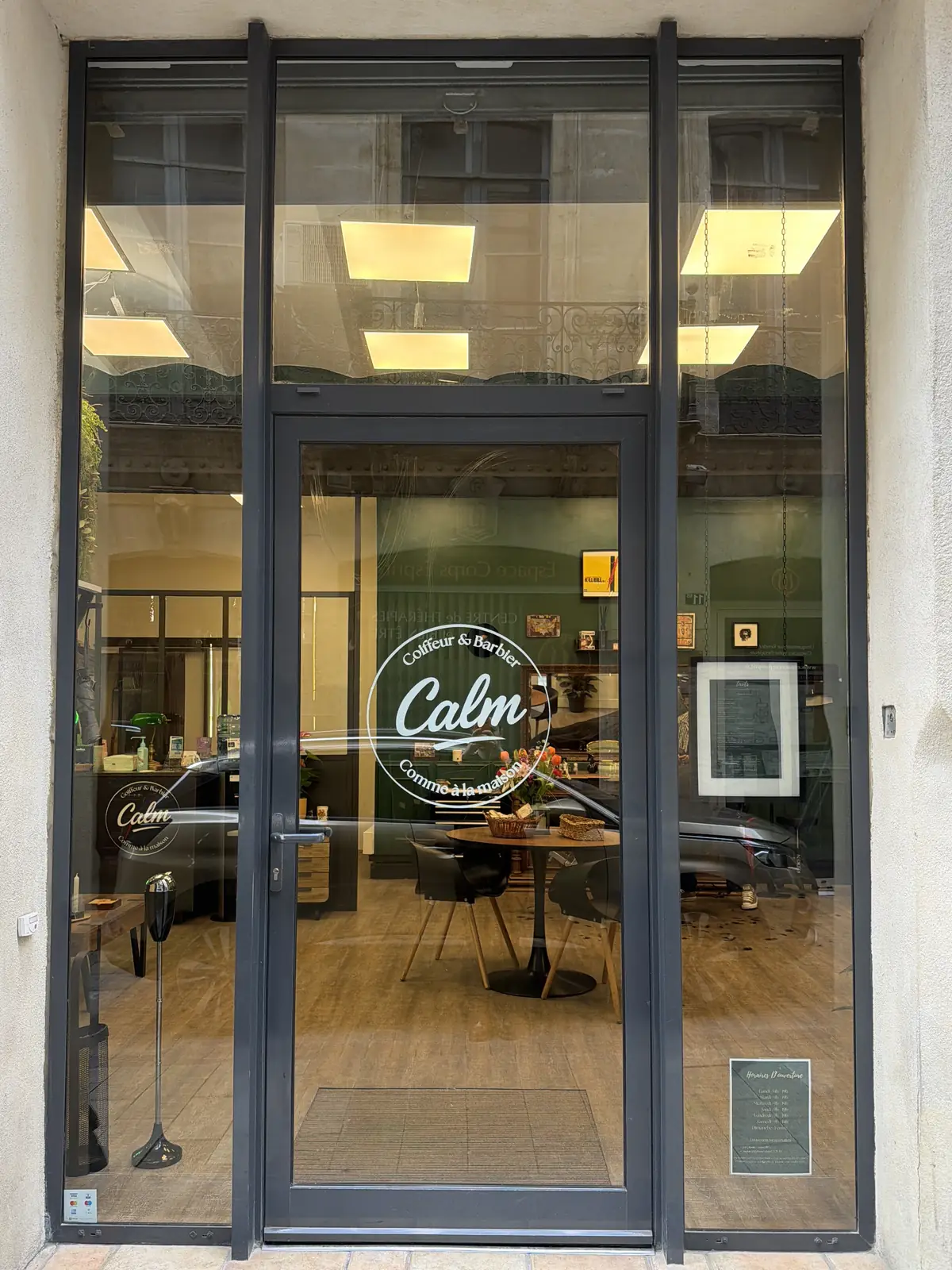 Devanture vitrée du salon CALM Coiffeur & Barbier à Montpellier.