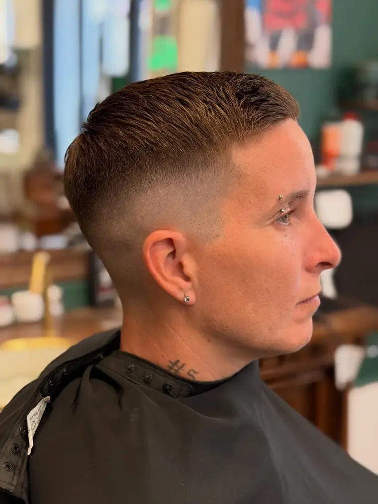 Coupe courte masculine avec dégradé net sur les côtés, réalisée chez CALM.