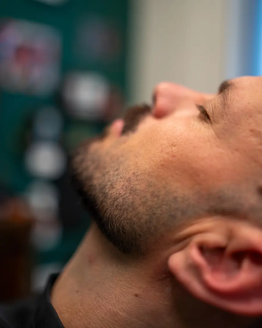 Taille de barbe chez CALM : contours du cou dessinés nets sous la mâchoire.